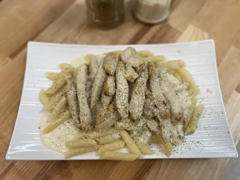 Chicken Alfredo: grilled chicken strips over penne in Alfredo sauce, dusted with parmesan and herbs
